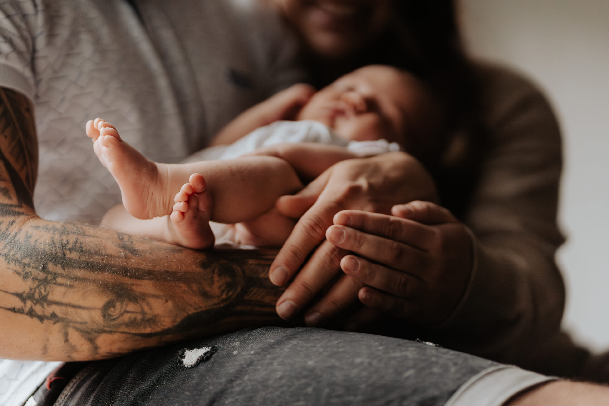 Close-up of a mother's hand gently holding her baby's tiny feet, symbolizing warmth and affection.